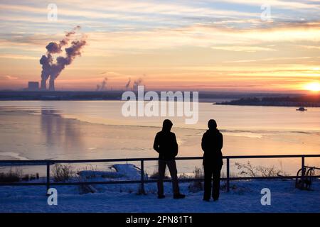 Vista sul lago ghiacciato di Störmthal in inverno. cielo colorato al tramonto. riflessione della centrale di lippendorf sul ghiaccio. Foto Stock