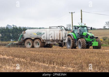 Ballynascubbig, West Cork, Irlanda. 17th Apr, 2023. Il coltivatore Liam Ryan, che coltiva suini e prodotti lattiero-caseari, distribuisce liquami su un campo di 80 acri utilizzando uno spanditore con barra di sgranatura Conor 3500 TR, trainato da un trattore Deutz-Fahr 7250 a una velocità di 3.000 litri per acro. Credit: AG News/Alamy Live News Foto Stock