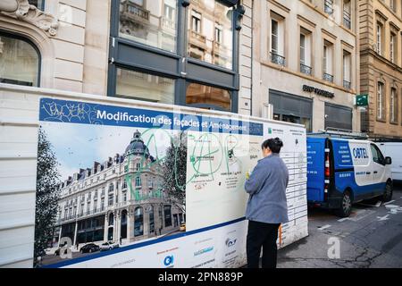 Strasburgo, Francia - Mar 20, 2023: Una donna sta rimuovendo i graffiti da un edificio esterno in una zona urbana dell'Alsazia, Francia, dopo la manifestazione dei manifestanti Foto Stock