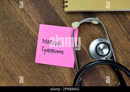 Concetto di sindrome di Marfan scrivere su note appiccicose con stetoscopio isolato su tavola di legno. Foto Stock