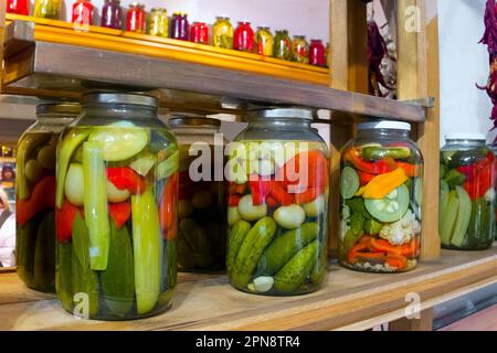 La conservazione è in piedi su un banco. Verdure sottaceto in una banca, cetrioli, pepe Foto Stock