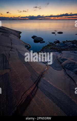 Splendida vista sulla costa rocciosa, la scogliera e il Mar Baltico a Hanko, Finlandia, al tramonto in estate. Foto Stock