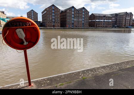 Gloucester, Regno Unito. 13th aprile 2023. Una lifboa è raffigurata di fronte ai magazzini residenziali convertiti a Gloucester Docks. Gli storici moli di Gloucester, il porto più interno della Gran Bretagna, si trovano all'incrocio settentrionale del fiume Severn con il Gloucester e il canale Sharpness. Credit: Notizie dal vivo di Mark Kerrison/Alamy Foto Stock