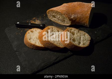 Fette di pane con briciole su sfondo nero. Vista frontale. Piatti fatti in casa. Foto Stock