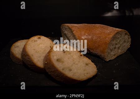 Fette di pane con briciole su sfondo nero. Vista frontale. Piatti fatti in casa. Foto Stock