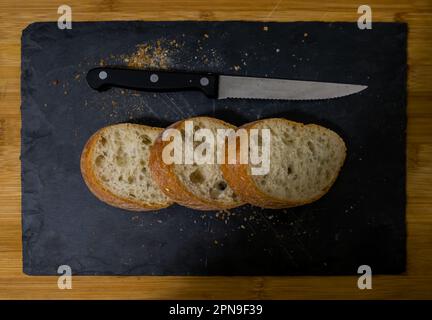 Fette di pane con briciole su sfondo nero. Vista frontale. Piatti fatti in casa. Foto Stock