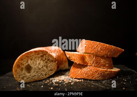 Fette di pane con briciole su sfondo nero. Vista frontale. Piatti fatti in casa. Foto Stock