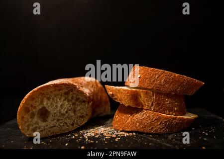 Fette di pane con briciole su sfondo nero. Vista frontale. Piatti fatti in casa. Foto Stock