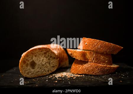 Fette di pane con briciole su sfondo nero. Vista frontale. Piatti fatti in casa. Foto Stock