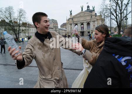 Lviv, Ucraina. 17th Apr, 2023. Gli ucraini versano acqua l'uno sull'altro sulla strada nel centro della città in mezzo all'invasione russa in Ucraina. La consuetudine di scopare con l'acqua è un antico rito di purificazione primaverile che si svolge il lunedì di Pasqua. Credit: SOPA Images Limited/Alamy Live News Foto Stock