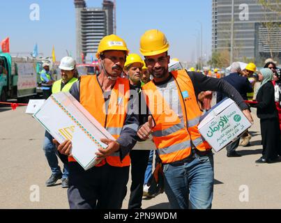 Cairo, Egitto. 16th Apr, 2023. Le persone trasportano scatole di cibo donato durante un evento di beneficenza al Cairo, Egitto, il 16 aprile 2023. L'ambasciata cinese in Egitto e la Camera di Commercio cinese in Egitto hanno organizzato un evento di distribuzione alimentare la domenica per gli egiziani bisognosi durante il Ramadan. Credit: Sui Xiankai/Xinhua/Alamy Live News Foto Stock