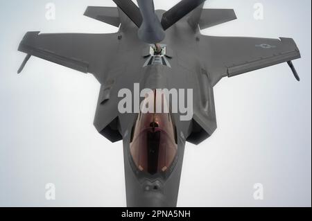 NEGLI STATI UNITI Air Force F-35A Lightning II assegnato al 355th Fighter Squadron riceve carburante da un KC-135 Stratotanker assegnato al 909th Air Refueling Squadron durante un esercizio aereo bilaterale con i combattenti della Japan Air Self-Defense Force sull'Oceano Pacifico, 14 aprile 2023. Le operazioni bilaterali esemplificano la capacità dell'alleanza tra Stati Uniti e Giappone di rispondere in modo rapido e deciso alle minacce all'interno della regione dell'Indo-Pacifico. (STATI UNITI Foto dell'aeronautica militare di Jessi Roth) Foto Stock