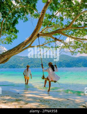 Isola di Koh Ra Wi in Thailandia vicino a Ko Lipe, con un paio di uomini e donne che si rilassano sulla spiaggia del Parco Nazionale di Tarutao Foto Stock