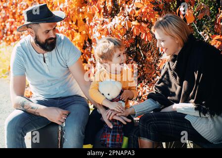 Tempo per la famiglia. Avventura con figlio. Pronto per un lungo viaggio. Padre e madre valigia e figlio. Papà e mamma bearded che raccontano a figlio di viaggiare. Inizio Foto Stock