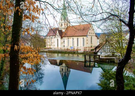 La chiesa monastica dell'ex Abbazia Benedettina di Blaubeuren, fondata intorno al 1085, vista attraverso il Blautopf, la sorgente carsica del fiume Blau, in Foto Stock