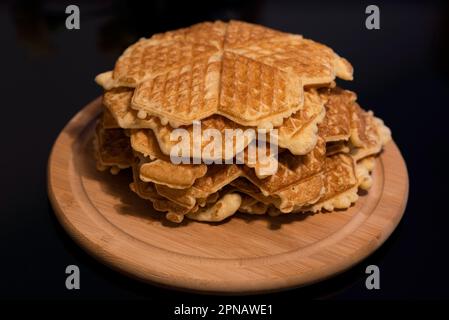 Mucchio di waffle fatti in casa su un piatto di legno Foto Stock