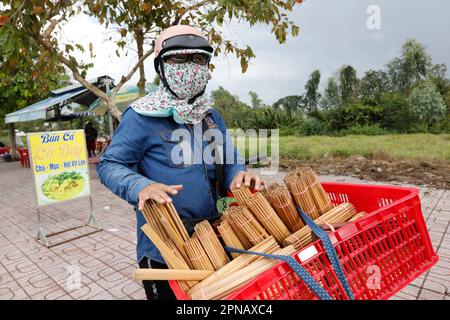 Donna che vende bacchette di legno. Chau Doc. Vietnam. Foto Stock