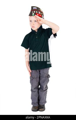 Giovane ragazzo caucasico che saluta guardando a sinistra giocando dressups in camicia verde cappello russo pieghevole esercito - pilotka - dall'esercito rosso sovietico con spilli isolati Foto Stock