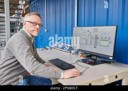 PRODUZIONE - 05 aprile 2023, Amburgo: Thomas Willner, ingegnere di processo e capo progetto di READi-PTL (distillazione reattiva), è presente presso un monitor dell'impianto con un reattore per la conversione dei materiali di scarto (grassi usati) nell'impianto pilota del dipartimento di ingegneria di processo presso il Life Sciences Campus di HAW. L'impianto pilota è progettato per convertire i materiali di scarto, come i grassi usati e i rifiuti di plastica, in un sostituto del petrolio pesante privo di olio e privo di carbonio. Il sostituto del petrolio (olio vegetale cracked CVO) può essere usato per produrre combustibili liquidi come benzina e diesel, così come plastica e molto m Foto Stock