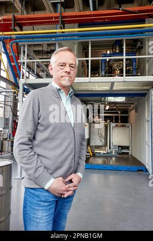 PRODUZIONE - 05 aprile 2023, Amburgo: Thomas Willner, ingegnere di processo e project leader di READi-PTL (distillazione reattiva) sta nel con un reattore per la conversione dei materiali di scarto (grassi usati) nello stabilimento pilota del dipartimento di ingegneria di processo presso il Life Sciences Campus di HAW. L'impianto pilota è progettato per convertire i materiali di scarto, come i grassi usati e i rifiuti di plastica, in un sostituto del petrolio pesante esente da olio neutro per il clima. Il sostituto del petrolio (olio vegetale cracked CVO) può essere usato per produrre combustibili liquidi come benzina e diesel, così come plastica e molto altro. Foto Foto Stock