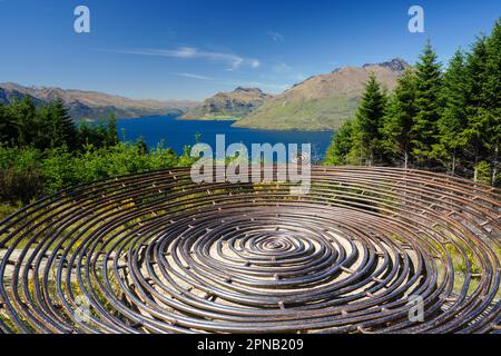 Salendo e su Queensland Hill in Nuova Zelanda sull'Isola Sud di Otago. Anche una vista del Lago Wakatipu con la montagna sullo sfondo. Foto Stock