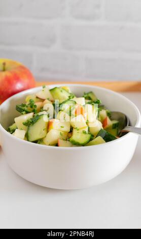 Insalata di frutta e verdura cruda con cetriolo a cubetti e mele marinate con miele, succo di limone, olio d'oliva e prezzemolo Foto Stock
