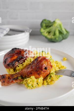 Bricioli di pollo al forno e smaltati con curry, riso broccoli in un piatto Foto Stock