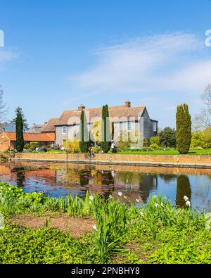 RHS Hyde Hall Hill Top Building con il lago a Foreground in una luminosa e soleggiata mattina di aprile Foto Stock