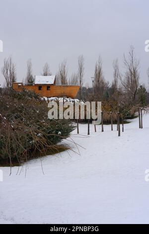Smaal barca di legno sotto la neve tra cespugli e alberi Foto Stock