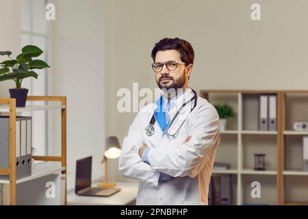 Ritratto di medico fiducioso maschio in piedi con le braccia incrociate Foto Stock