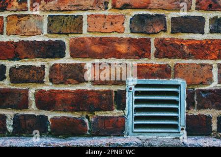 Piccola griglia di ventilazione in metallo sulla parete in mattoni a Halmstad, Svezia Foto Stock