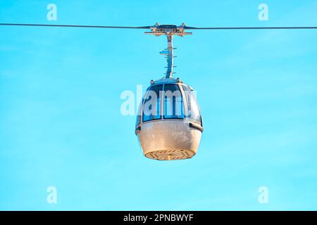 Primo piano di una cabinovia da sci recintata posta su uno sfondo blu chiaro. Foto Stock