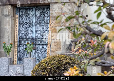 Porte ornate e sotoba commemorativa nel cimitero di Yanaka in un vecchio quartiere di Tokyo in Giappone Foto Stock