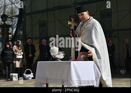 LVIV, UCRAINA - 15 APRILE 2023 - Un sacerdote conduce la benedizione dei cesti pasquali nella Cattedrale di San Giorgio il sabato Santo, Lviv, Ucraina occidentale. Foto Stock