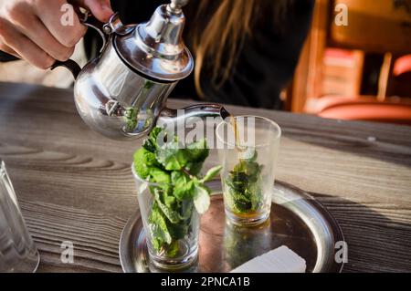 Tradizionale teiera marocchina con una tazza all'aperto pronta per essere bevuta Foto Stock