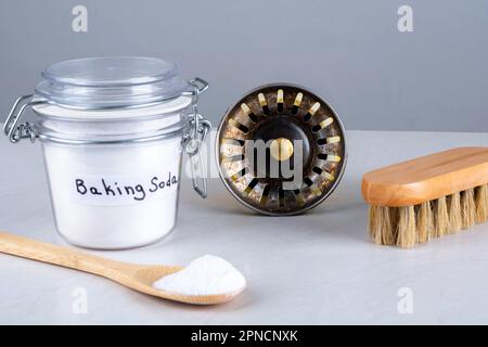 Bicarbonato di sodio, foro per lavello da cucina e spazzola di legno, cucchiaio sul piano di appoggio. Il concetto di scarico di dispersore organico di unclog Foto Stock