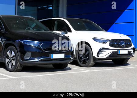 Batteria nera Mercedes-Benz EQA 250 SUV elettrico anno 2023 e nuovo SUV bianco Mercedes-Benz 4MATIC con griglia diamantata. Salo, Finlandia. Aprile 10, 2023. Foto Stock