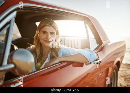 Im non sprecare questa bella giornata al chiuso. Ritratto di una bella giovane donna in viaggio in spiaggia. Foto Stock