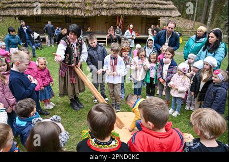 LVIV, UCRAINA - 16 APRILE 2023 - Una donna parla ai bambini durante la celebrazione pasquale al Museo di architettura popolare di Klymentii Sheptytskyi e. Foto Stock