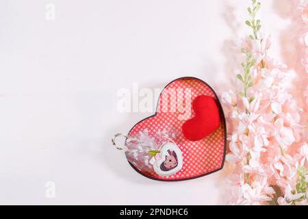 Ogni giorno è il giorno della mamma. I concetti del giorno della madre e del giorno più bello, concetto dell'amore. Cuore rosso con la lettera AMORE MAMMA con bel fiore su sfondo rosa Foto Stock