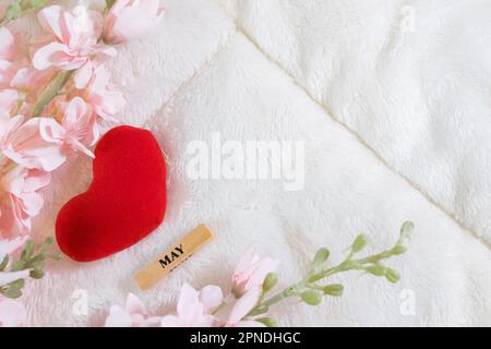 Ogni giorno è il giorno della mamma. I concetti del giorno della madre e del giorno più bello, concetto dell'amore. Cuore rosso con la lettera AMORE MAMMA con bel fiore su sfondo rosa Foto Stock