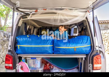 bambino in un camper sopra i bagagli Foto Stock