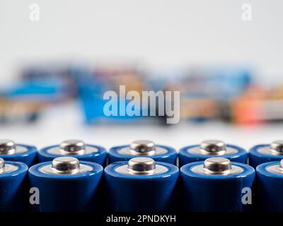 Batterie alcaline su sfondo chiaro. Il concetto di fonti di energia e il loro uso. Molte batterie AA. Foto Stock