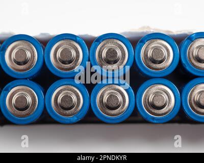 Batterie alcaline su sfondo chiaro. Il concetto di fonti di energia e il loro uso. Molte batterie AA. Foto Stock