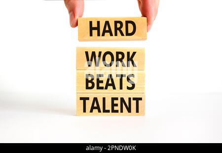 Il duro lavoro batte il simbolo del talento. Concetto parole duro lavoro batte il talento su woodenblock. Bellissimo sfondo bianco tavolo. Business motivazionale difficile Foto Stock