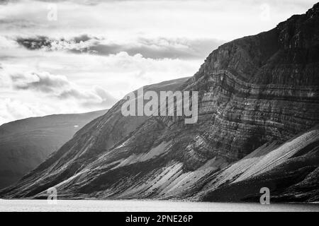 Strati di sedimenti visibili sul lato delle montagne lungo la riva del Fjord di Saglek nel nord di Labrador, Canada. Foto Stock