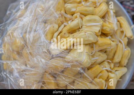 Il jackfruit, maturo e semi-chiuso con coperchio in plastica trasparente e pronto per essere venduto, è di colore giallo. Foto Stock