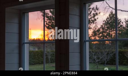 Splendida vista dalla finestra sul giardino e sul cortile ai raggi del sole. Profondità di campo bassa Foto Stock