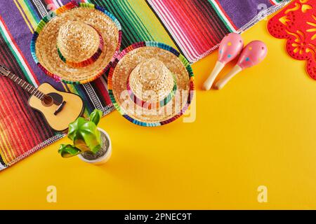 Cinco de Mayo sfondo vacanza. Maracas, cactus e cappello su sfondo giallo Foto Stock