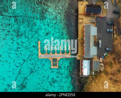 Vista aerea del molo in legno, acqua azzurra, case sulla costa del mare Foto Stock